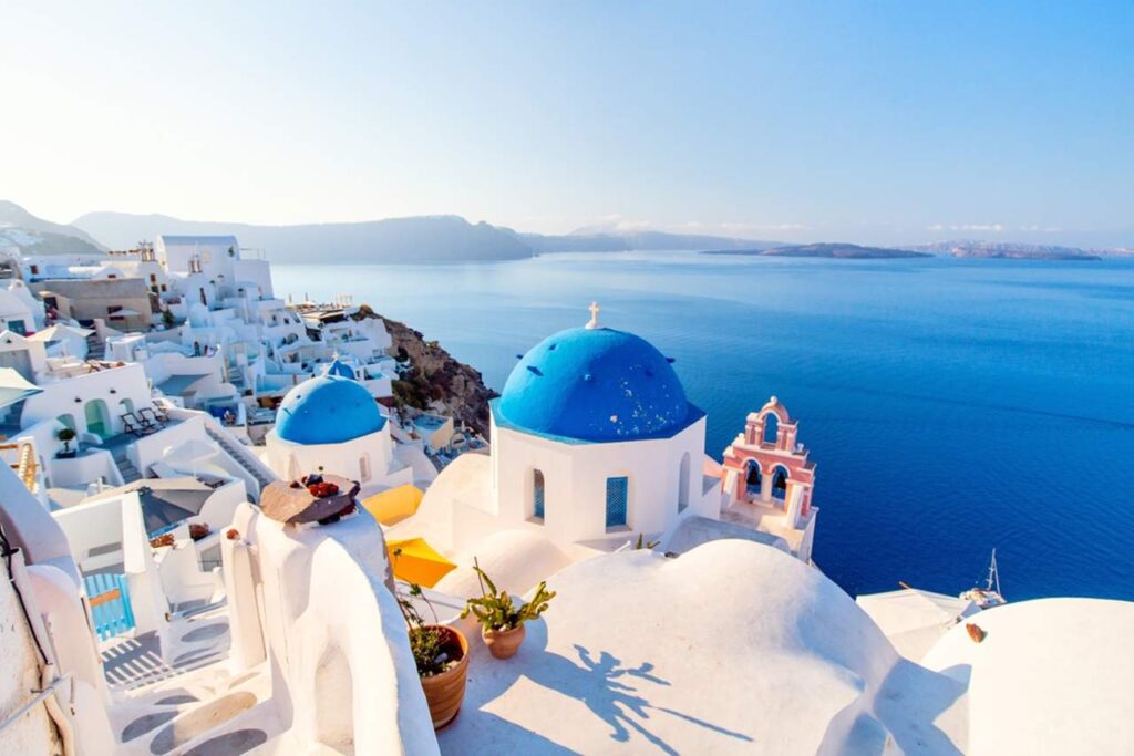 Blue,Domed,Church,In,Oia,Overlooking,Spectacular,Caldera,Surrounding,Beautiful