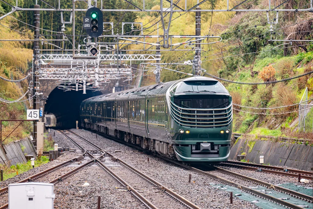 Tren de lujo JR Twilight Express Mizukaze circulando entre montañas verdes de Japón